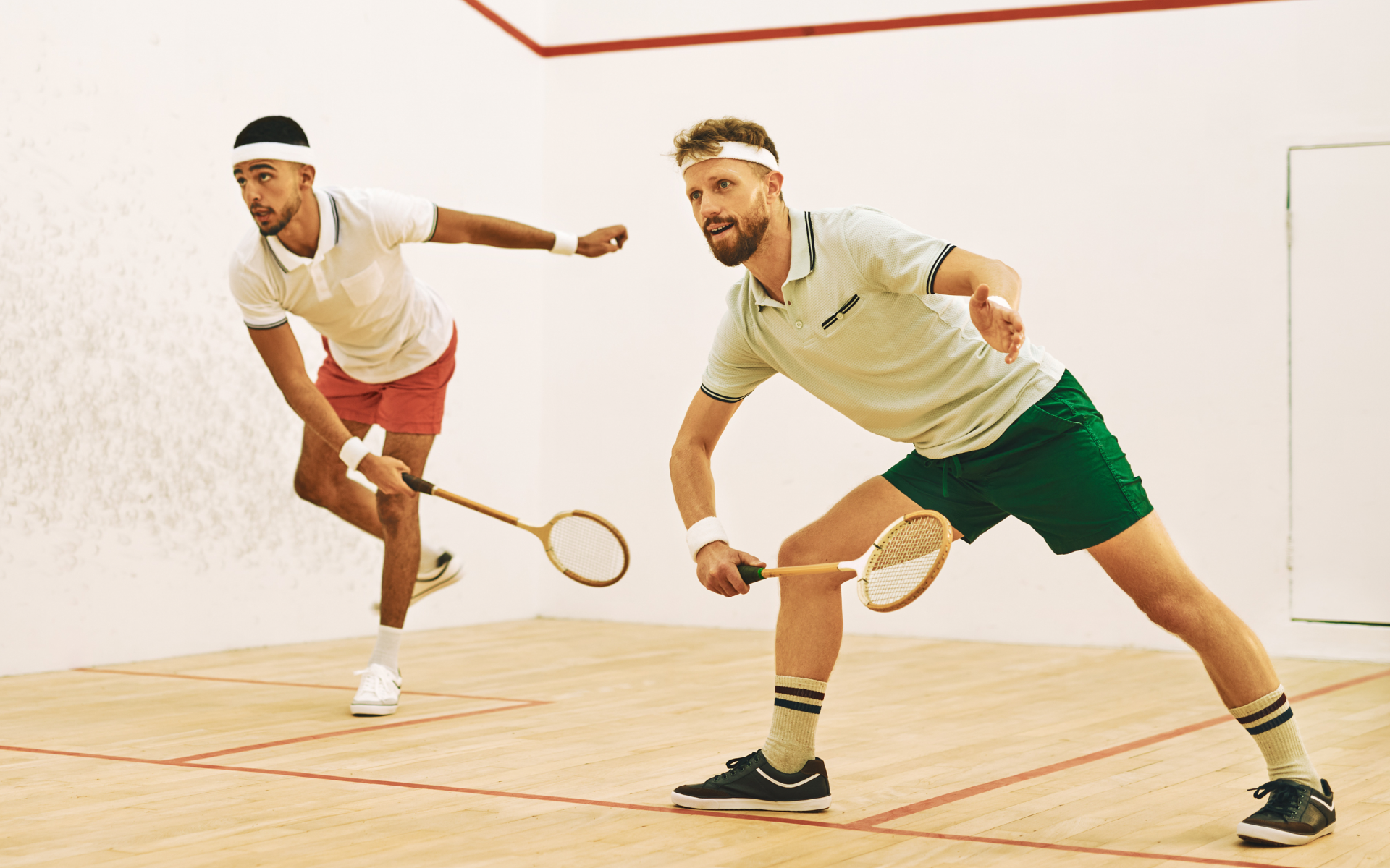 Two men playing squash on court.